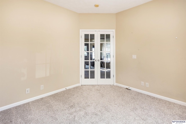 empty room with carpet floors, baseboards, and french doors