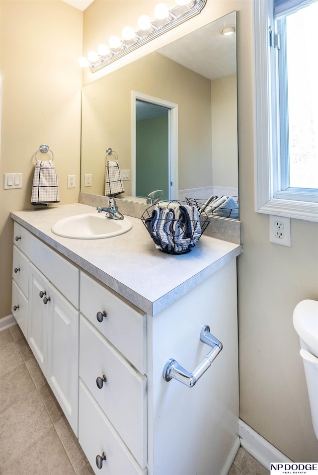bathroom featuring tile patterned floors, baseboards, and vanity