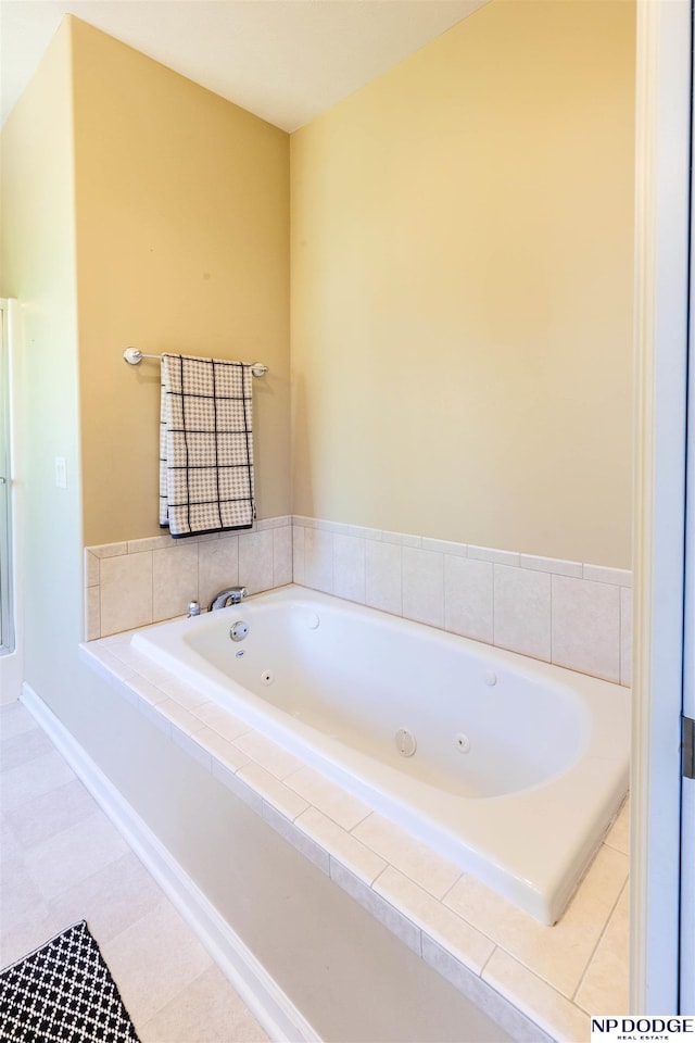 bathroom with a tub with jets and baseboards
