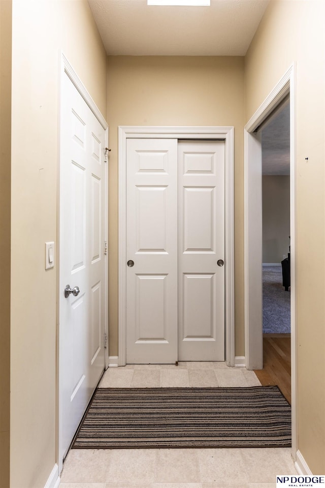 hallway with baseboards and light tile patterned flooring