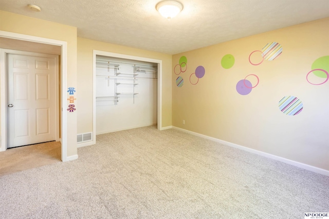 unfurnished bedroom with carpet flooring, baseboards, visible vents, and a closet