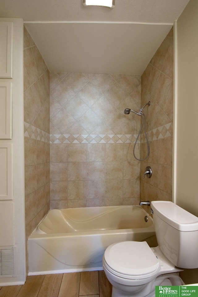 bathroom with toilet, tub / shower combination, and visible vents