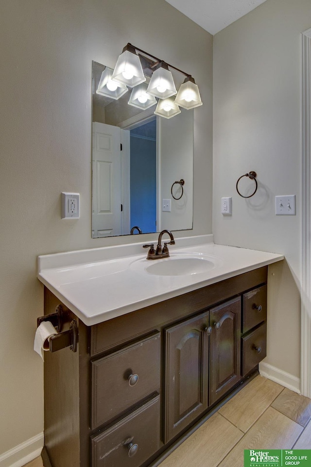 bathroom featuring vanity, baseboards, and wood finished floors