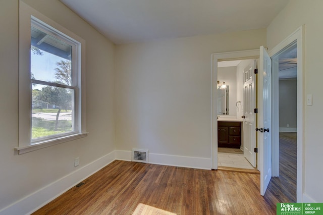 unfurnished bedroom featuring visible vents, wood finished floors, and baseboards