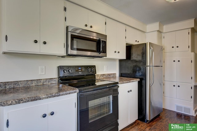 kitchen featuring stainless steel appliances, visible vents, dark wood finished floors, white cabinetry, and dark countertops