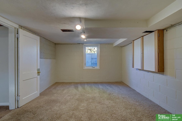 below grade area featuring carpet, visible vents, and concrete block wall