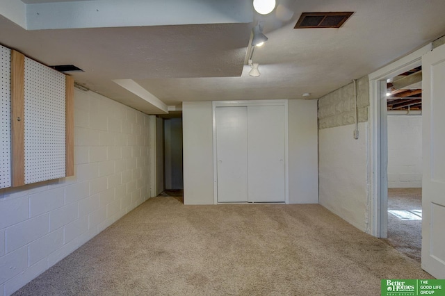 unfurnished bedroom featuring carpet, visible vents, and concrete block wall