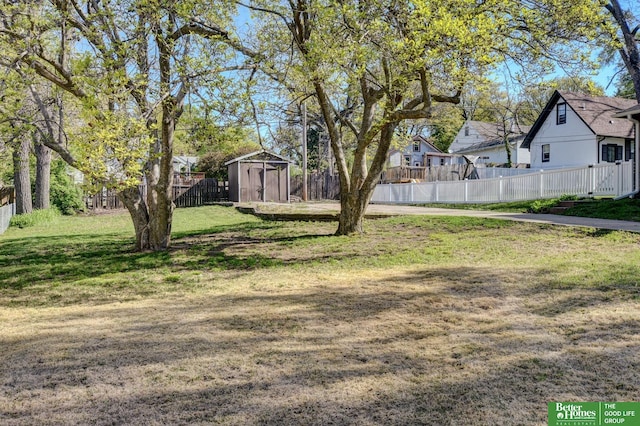 view of yard with a fenced backyard, an outdoor structure, and a shed