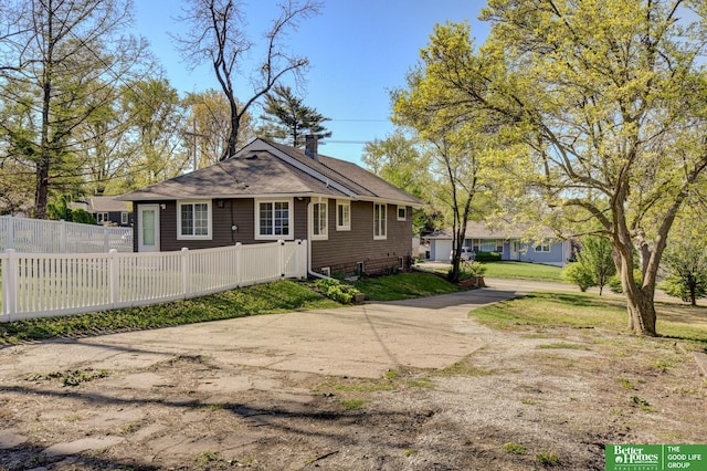 view of front facade featuring a chimney, fence, and a front yard