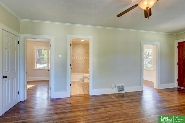 unfurnished bedroom featuring crown molding, baseboards, visible vents, and wood finished floors