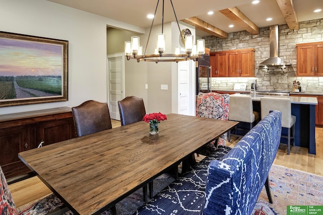 dining space with recessed lighting, beamed ceiling, a chandelier, and light wood finished floors