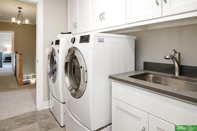 laundry room featuring cabinet space, separate washer and dryer, ornamental molding, and a sink