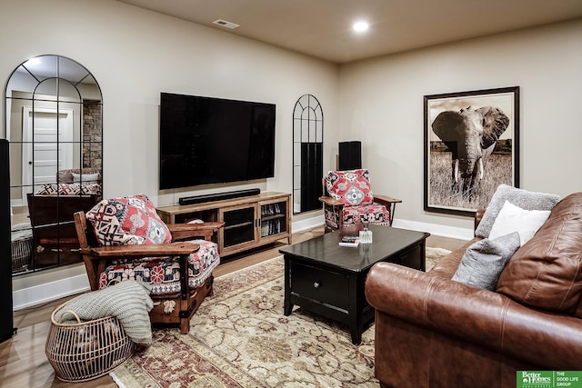 living room with baseboards, recessed lighting, wood finished floors, and visible vents