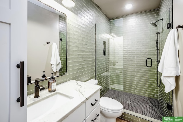 bathroom with recessed lighting, vanity, a shower stall, and toilet