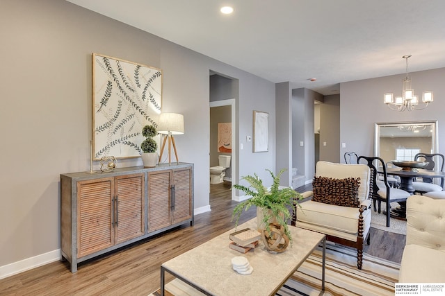 living area featuring an inviting chandelier, recessed lighting, light wood-style flooring, and baseboards