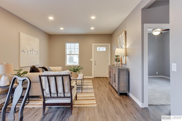 living area featuring baseboards, recessed lighting, and light wood-type flooring