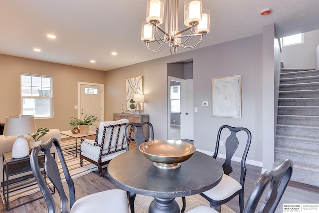 dining area featuring recessed lighting, stairs, wood finished floors, and a chandelier