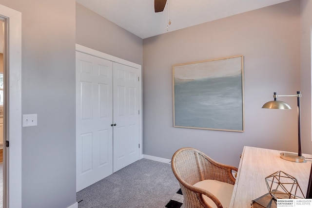 carpeted office with baseboards and a ceiling fan