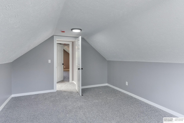 bonus room featuring a textured ceiling, carpet, baseboards, lofted ceiling, and visible vents
