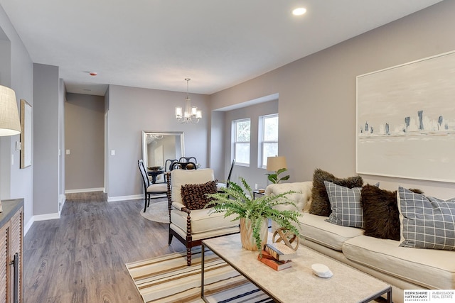 living room featuring baseboards, wood finished floors, and a chandelier