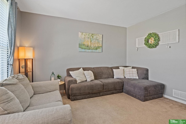living area featuring visible vents, baseboards, carpet floors, and a wealth of natural light
