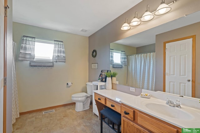 bathroom featuring visible vents, baseboards, toilet, and vanity