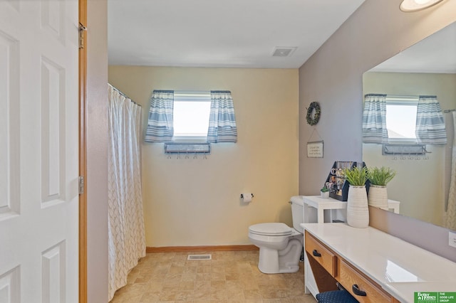 bathroom with visible vents, a healthy amount of sunlight, and toilet