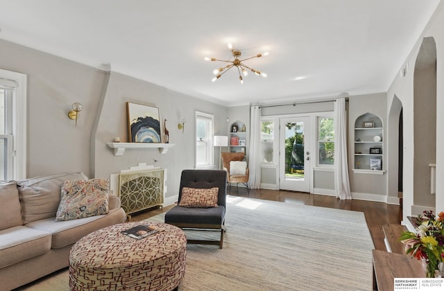 5117 Western Ave, Omaha, NE 68132 - living room with wood finished floors, a chandelier, arched walkways, baseboards, and a fireplace
