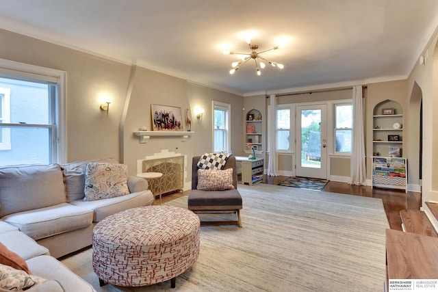 5117 Western Ave, Omaha, NE 68132 - living room with a chandelier, built in features, wood finished floors, baseboards, and ornamental molding