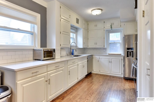 5117 Western Ave, Omaha, NE 68132 - kitchen featuring a sink, stainless steel appliances, light wood finished floors, and healthy amount of natural light
