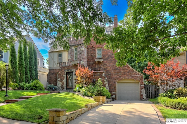 5117 Western Ave, Omaha, NE 68132 - tudor-style house featuring brick siding, concrete driveway, a front yard, and a garage