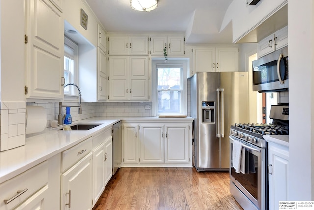 5117 Western Ave, Omaha, NE 68132 - kitchen with appliances with stainless steel finishes, a sink, healthy amount of natural light, and light countertops