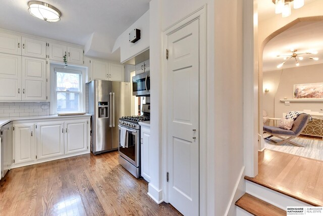5117 Western Ave, Omaha, NE 68132 - kitchen with stainless steel appliances, light countertops, white cabinets, light wood finished floors, and backsplash