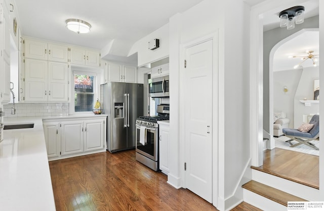 5117 Western Ave, Omaha, NE 68132 - kitchen with stainless steel appliances, light countertops, tasteful backsplash, white cabinets, and dark wood-style floors