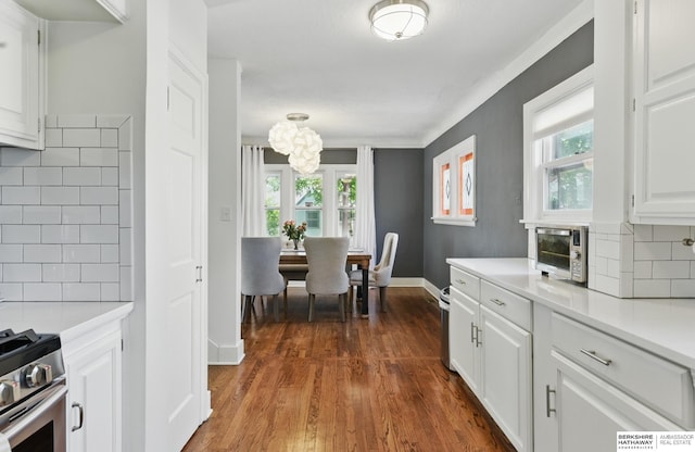 5117 Western Ave, Omaha, NE 68132 - kitchen featuring tasteful backsplash, light countertops, white cabinetry, and dark wood finished floors
