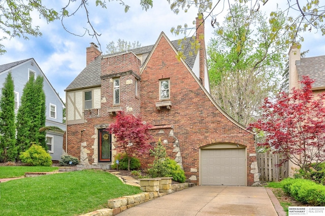 5117 Western Ave, Omaha, NE 68132 - tudor house featuring brick siding, driveway, a chimney, and a garage
