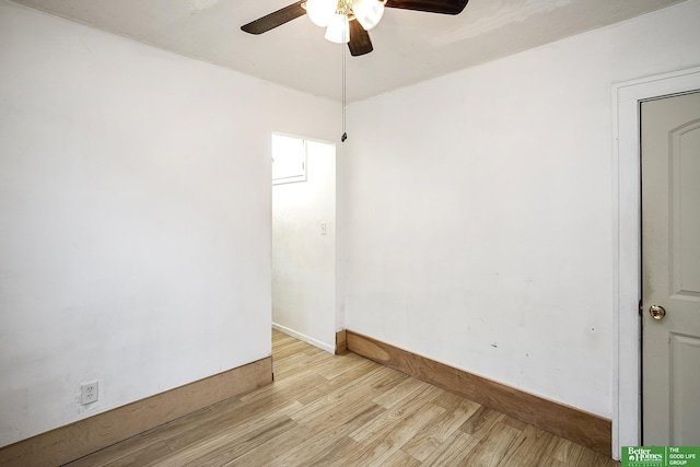 spare room featuring baseboards, ceiling fan, and light wood-type flooring