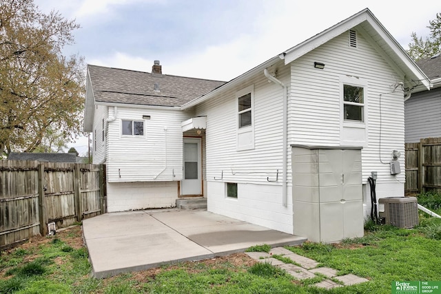 back of house featuring fence, central AC, entry steps, a chimney, and a patio area