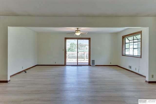 spare room with light wood-style floors, baseboards, ceiling fan, and visible vents