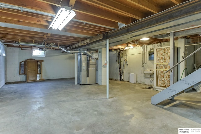 basement featuring heating unit and concrete block wall