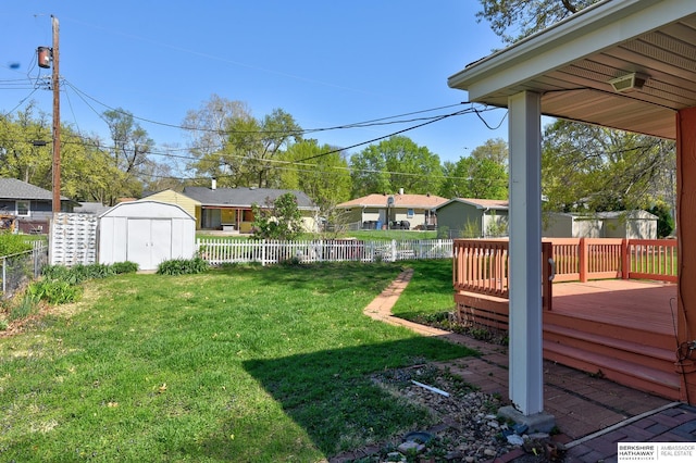 view of yard with a deck, an outbuilding, a fenced backyard, and a storage unit