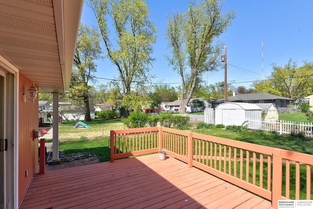 wooden deck with a yard, a fenced backyard, and a shed