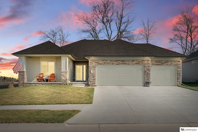 ranch-style home featuring a front lawn, stone siding, a shingled roof, concrete driveway, and an attached garage