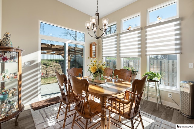 dining room with an inviting chandelier, wood finished floors, and visible vents