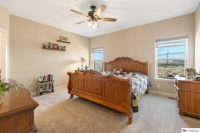 carpeted bedroom with baseboards, a ceiling fan, and multiple windows
