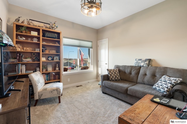 living area with baseboards, a notable chandelier, carpet flooring, and visible vents