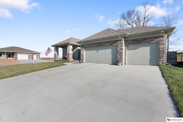 single story home featuring a front yard, concrete driveway, an attached garage, a shingled roof, and stone siding