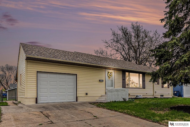 ranch-style home featuring an attached garage, concrete driveway, and a front lawn