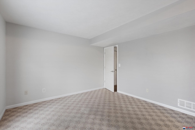empty room with carpet flooring, baseboards, and visible vents