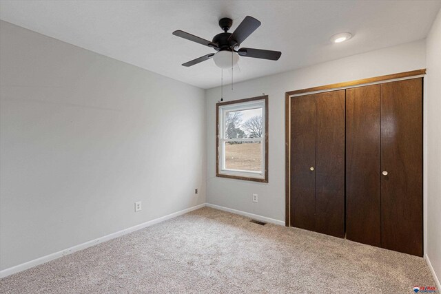unfurnished bedroom featuring visible vents, a closet, baseboards, a ceiling fan, and carpet